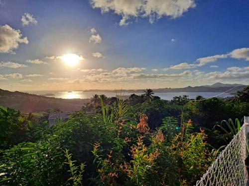 a view of the sun setting over the ocean at Zowanj 1 - Logement avec vue panoramique in Le Robert