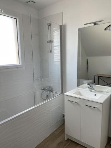 une salle de bain blanche avec une douche et un lavabo dans l'établissement Le Cottage de Louise, centre ville de Saint Valery, à Saint-Valery-sur-Somme