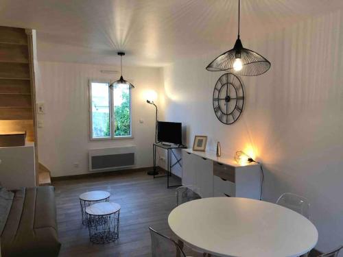 un salon avec une table et des chaises blanches dans l'établissement Le Cottage de Louise, centre ville de Saint Valery, à Saint-Valery-sur-Somme