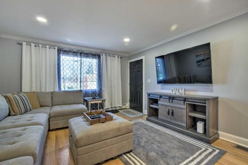 a living room with a couch and a flat screen tv at Modern Middletown Retreat, Minutes to Downtown! in Middletown