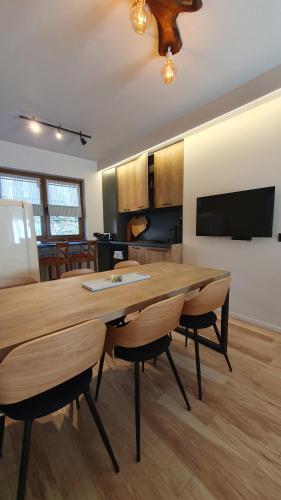 a kitchen and dining room with a wooden table and chairs at KOKICHE 4 Friends, Borovets in Borovets