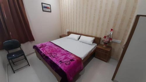 a small bedroom with a bed and a chair at Hotel Sunstays Oppsite Bus stand in Ajmer