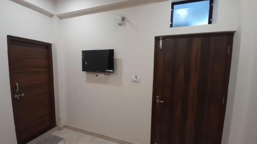 a room with a door and a television on the wall at Hotel Sunstays Oppsite Bus stand in Ajmer