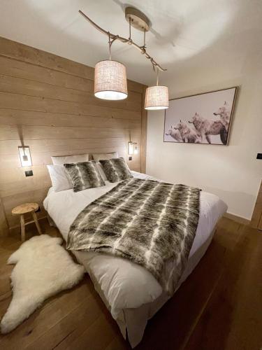 - une chambre avec un grand lit et deux lumières dans l'établissement Appartement de standing plein centre station, 50m des pistes, aux Gets