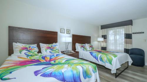 a bedroom with two beds with colorful pillows at All-New, Private, Huge TV, Heated Pool, Tiki Bar in Sarasota
