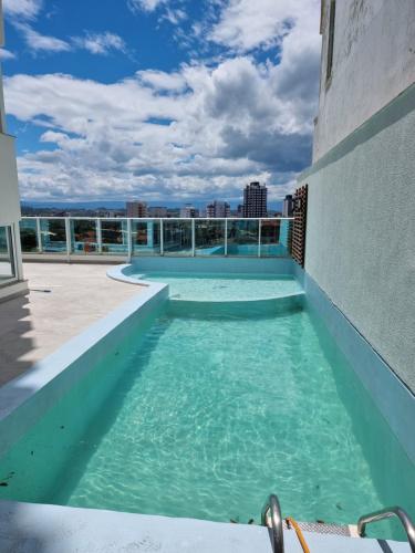 a swimming pool on the roof of a building at Apartamento espetacular, melhor vista e localização de Torres in Torres