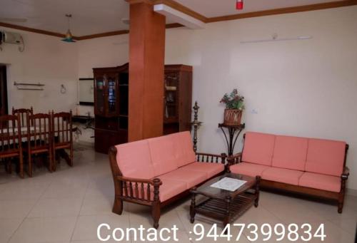 una sala de estar con 2 sofás rosas y una mesa. en Ritu Homestay (The Second Wind) en Thiruvananthapuram