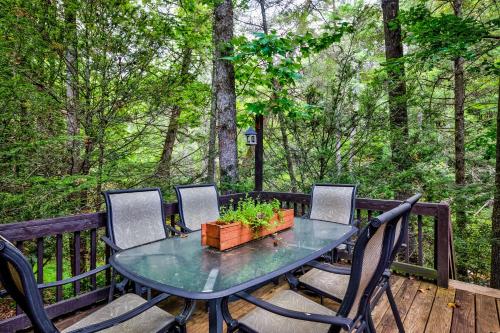 a table and chairs on a deck with trees at Rivers Edge in Suches