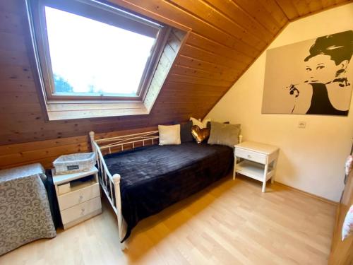 1 dormitorio con 1 cama y ventana en una habitación en Ferienwohnung - Grüne Oase en Stockach