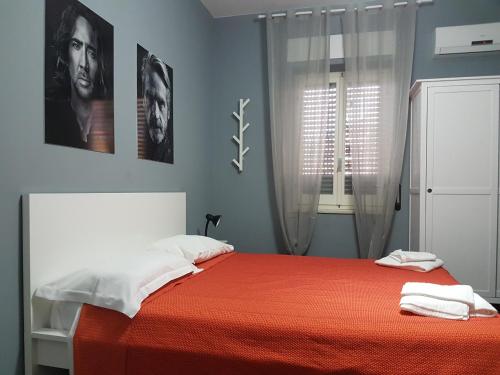 a bedroom with a bed with red sheets and a window at B&B Colors in Sellia Marina