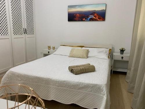 - une chambre avec un grand lit et des draps blancs dans l'établissement Apto na Av Brasil frente ao shopping,4min da praia, à Balneário Camboriú