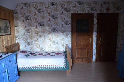 a bedroom with a bed and a floral wall at Śleboda wynajem pokoi Ewa Satoła in Biały Dunajec