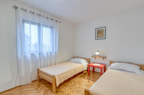dwa łóżka w pokoju z oknem w obiekcie Apartment Ana Coki w mieście Funtana