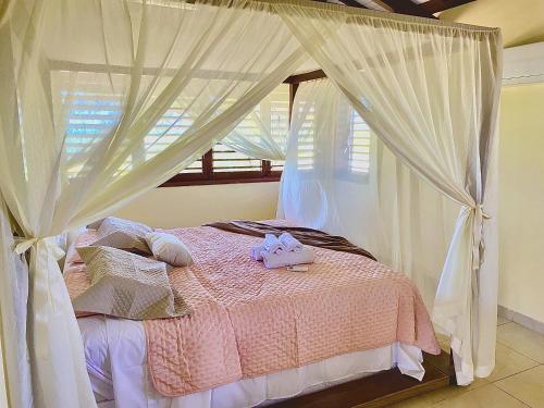 una camera con letto a baldacchino e tende bianche di Casa Pé na Areia - Jacumã, Vista Mar, Wi-Fi by PenareiaTurBr a Conde