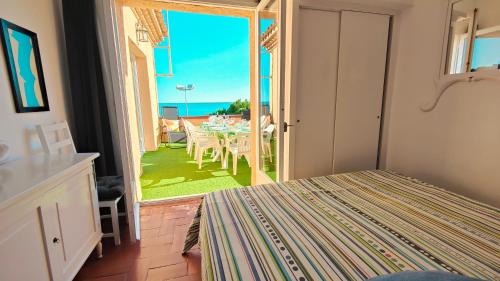 a bedroom with a bed and a view of the ocean at Apartamento con jardín a 11 metros de la playa. CG. in Palamós