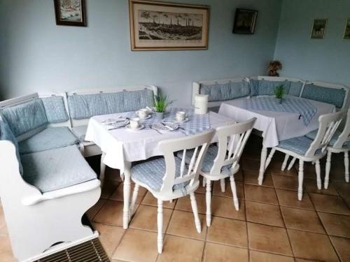 Pension Weidengrund في فالسروده: غرفة طعام مع طاولة بيضاء وكراسي