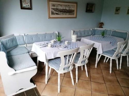 a dining room with a white table and chairs at Pension Weidengrund in Walsrode