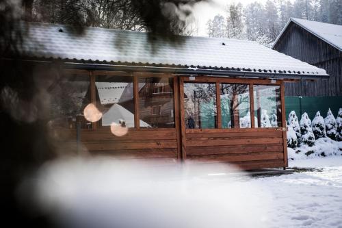 a large wooden cabin with snow on the ground at Chata Eva in Jezersko