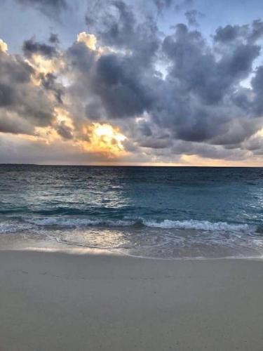 a beach with a cloudy sky and the ocean at Your ¥achting Home in Sousse