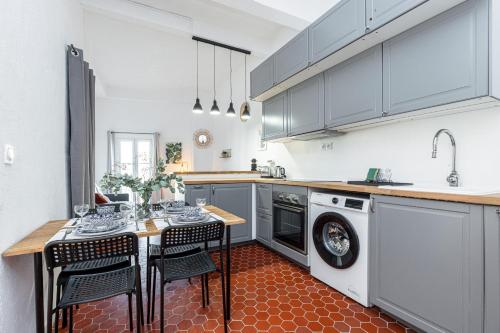 une cuisine avec une table et une machine à laver dans l'établissement Lovely 1 Bdr in Harbor Area, à Nice