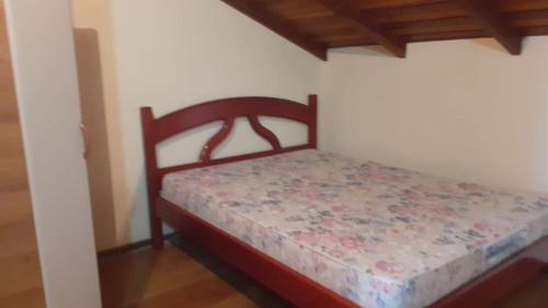 een klein bed in een kamer met een houten plafond bij Pousada Vila di Italia in Cidreira