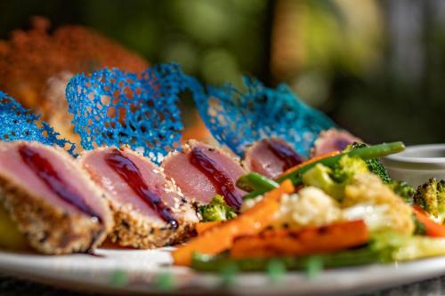 a plate of food with meat and vegetables on it at Cafe Playa Negra Hotel in Playa Negra
