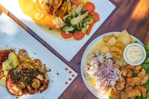 two plates of food on a wooden table at Cafe Playa Negra Hotel in Playa Negra
