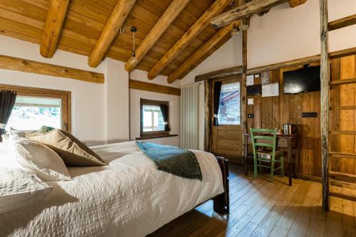 1 dormitorio con 1 cama y 1 mesa con silla en Chambres d'Hôtes - Li Tzatagni, en Pontboset