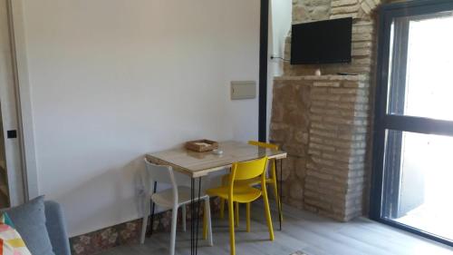 una mesa pequeña con sillas amarillas en una habitación en La Bodega, en Andújar