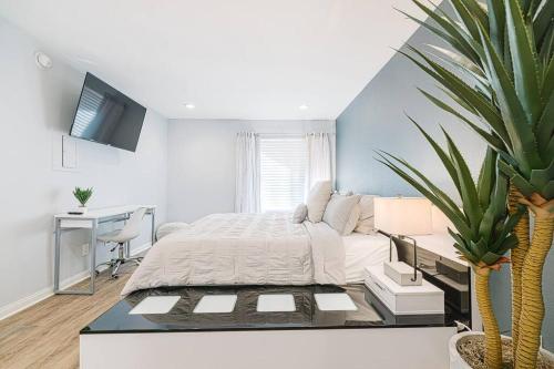 a bedroom with a bed and a desk and a plant at Resort-like luxurious condo in Woodland Hills, Los Angeles, Pool, Hot-tub, and more in Woodland Hills