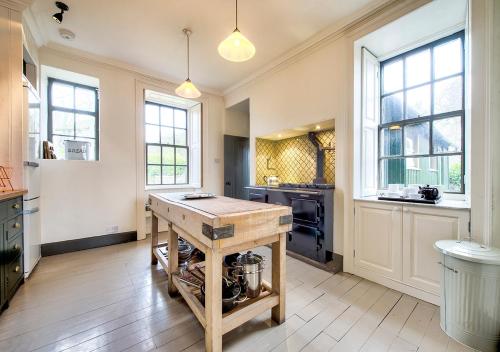 a kitchen with a wooden island in the middle at The Rock House - Main House in Edinburgh