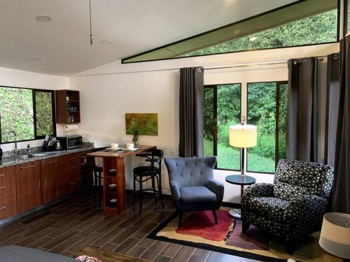 Modern cabin nestled in mountain nature. Paradise! في أوروسي: غرفة معيشة مع مطبخ مع طاولة وكراسي