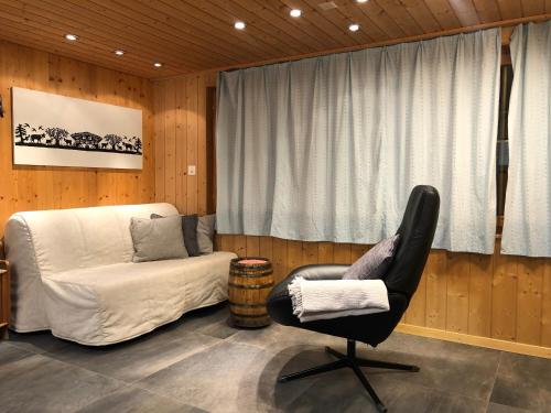 ein Schlafzimmer mit einem Stuhl, einem Bett und einem Fenster in der Unterkunft Chalet Weidli in Achseten
