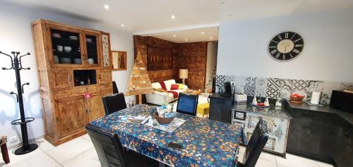 a kitchen with a table and a clock on the wall at Gīte du café Truchet in Saint-Pancrace