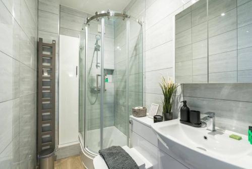 a white bathroom with a shower and a sink at Superb flat close to super famous Portobello Road in London