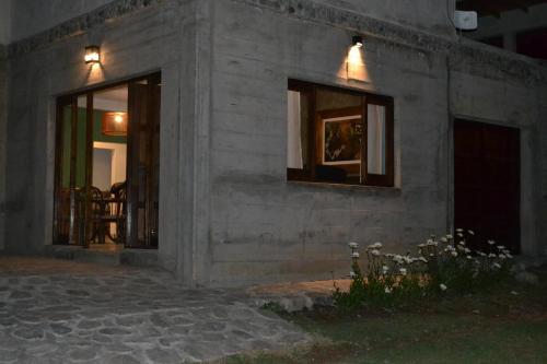 un edificio con dos ventanas con luces. en Aires del Alto - casas en Tafí del Valle