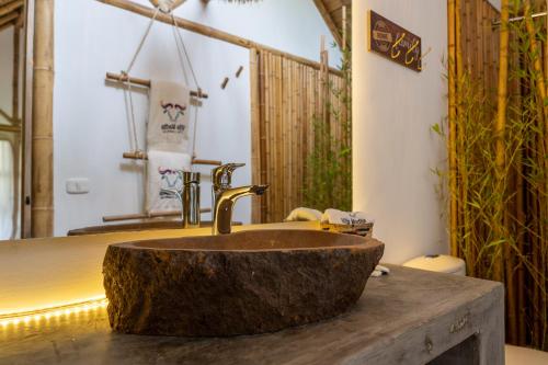 a bathroom with a stone sink on a wooden counter at Hotel Campestre Villa Martha in Turbaco