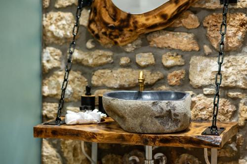 una ciotola di pietra su un tavolo di legno con lavandino di Βίλα Αρμονία Ορεινή Κορινθία a Krionérion