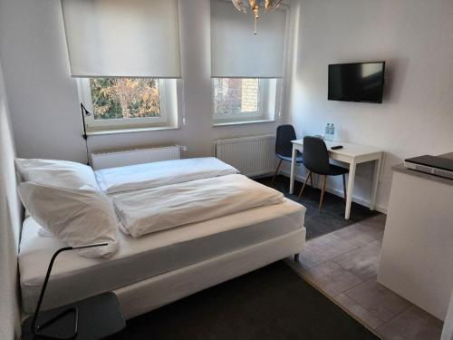 Dormitorio con cama, escritorio y TV en Davin City Aparments - Self-Check-In, en Hamburgo