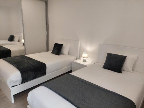 duas camas num quarto de hotel com duas lâmpadas em Apartment Til no Funchal