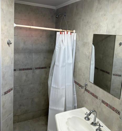 ein Badezimmer mit Duschvorhang und Waschbecken in der Unterkunft Nisanju in San Clemente del Tuyú