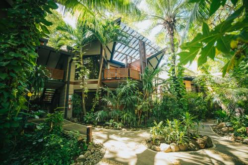 a house in the middle of a forest with palm trees at Hotel Bosque del Mar Playa Hermosa in Playa Hermosa