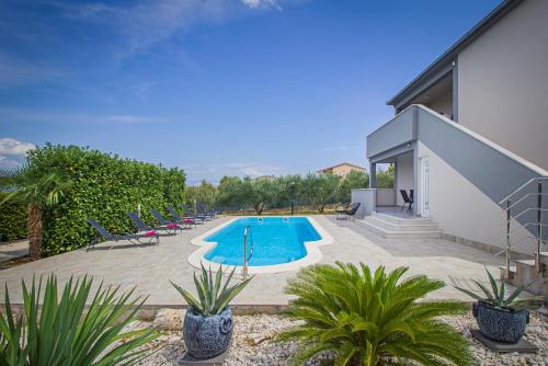 a swimming pool in the middle of a yard at Vila Rozarija in Trogir