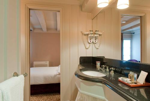 Un pat sau paturi într-o cameră la Hotel Odeon Saint-Germain