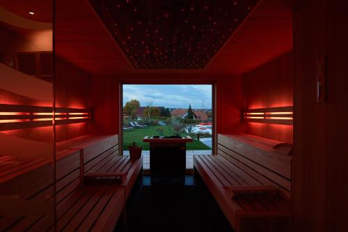 a red room with benches and a large window at Landhotel Haringerhof mit Saunawelt und Naturbadeteich in Grafenhausen