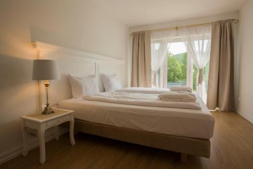 a bedroom with a large bed with a window at Dwór i Dworek Leszczowate Wellness & Spa in Ustrzyki Dolne