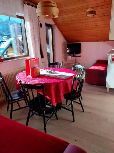 a dining room with a red table and chairs at APARTMA 27 in Kranjska Gora