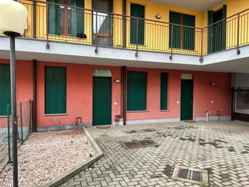 a building with red and green doors and a balcony at B e B House in Castellanza