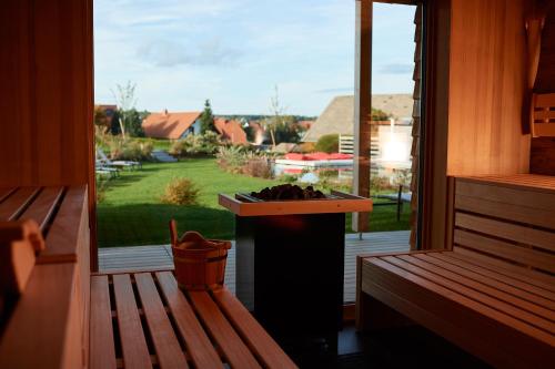 a porch with a bench and a window with a view of a yard at Landhotel Haringerhof mit Saunawelt und Naturbadeteich in Grafenhausen