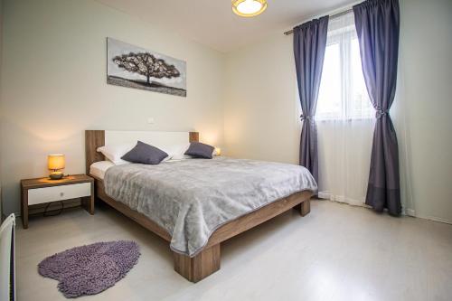 ein Schlafzimmer mit einem Bett mit einem Baumbild an der Wand in der Unterkunft Vila Rozarija in Trogir